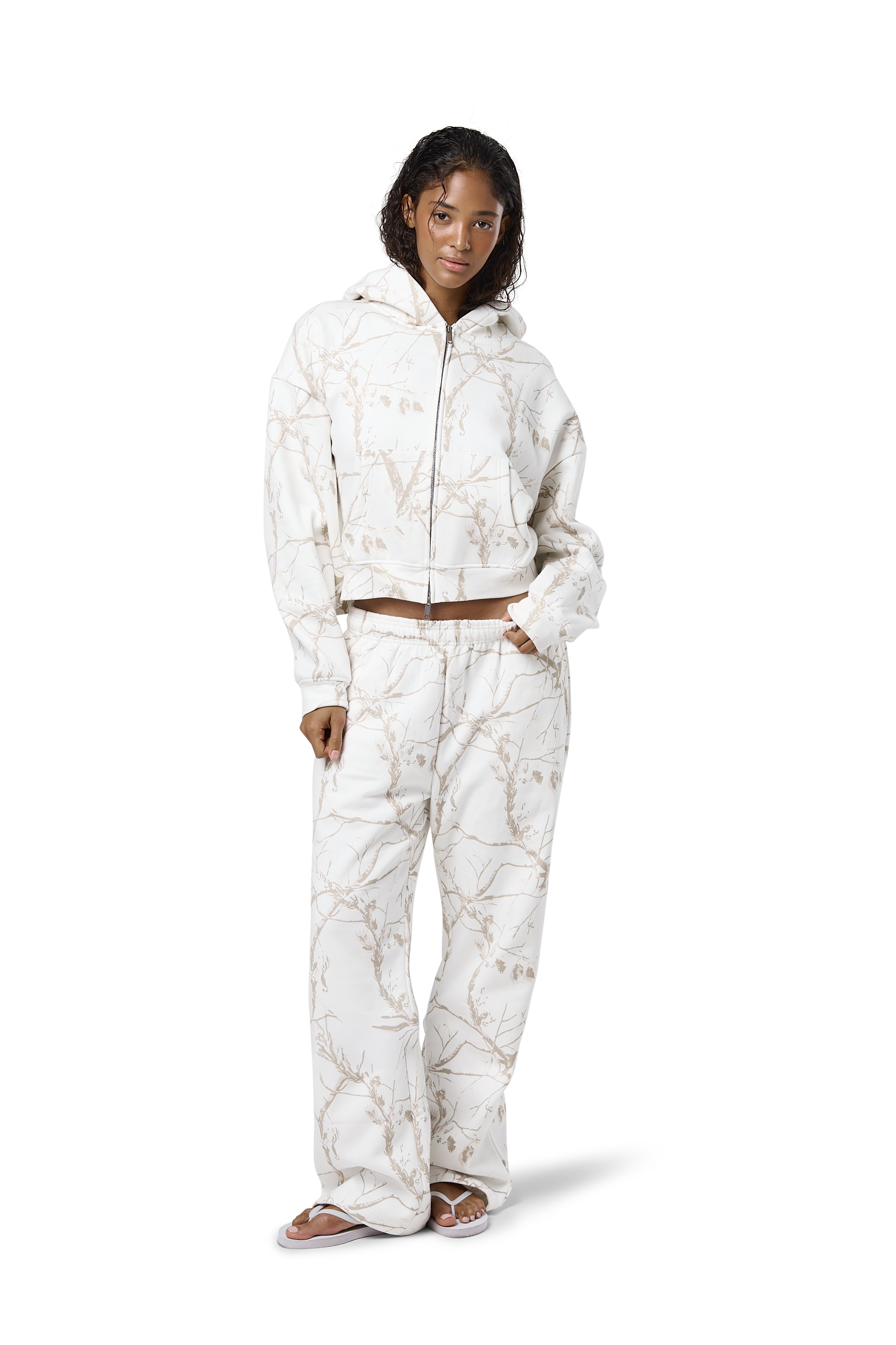 Off-white camouflage print sweatpants in a 'milk' shade, featuring a subtle twig pattern, available in petite, regular, and tall sizes.